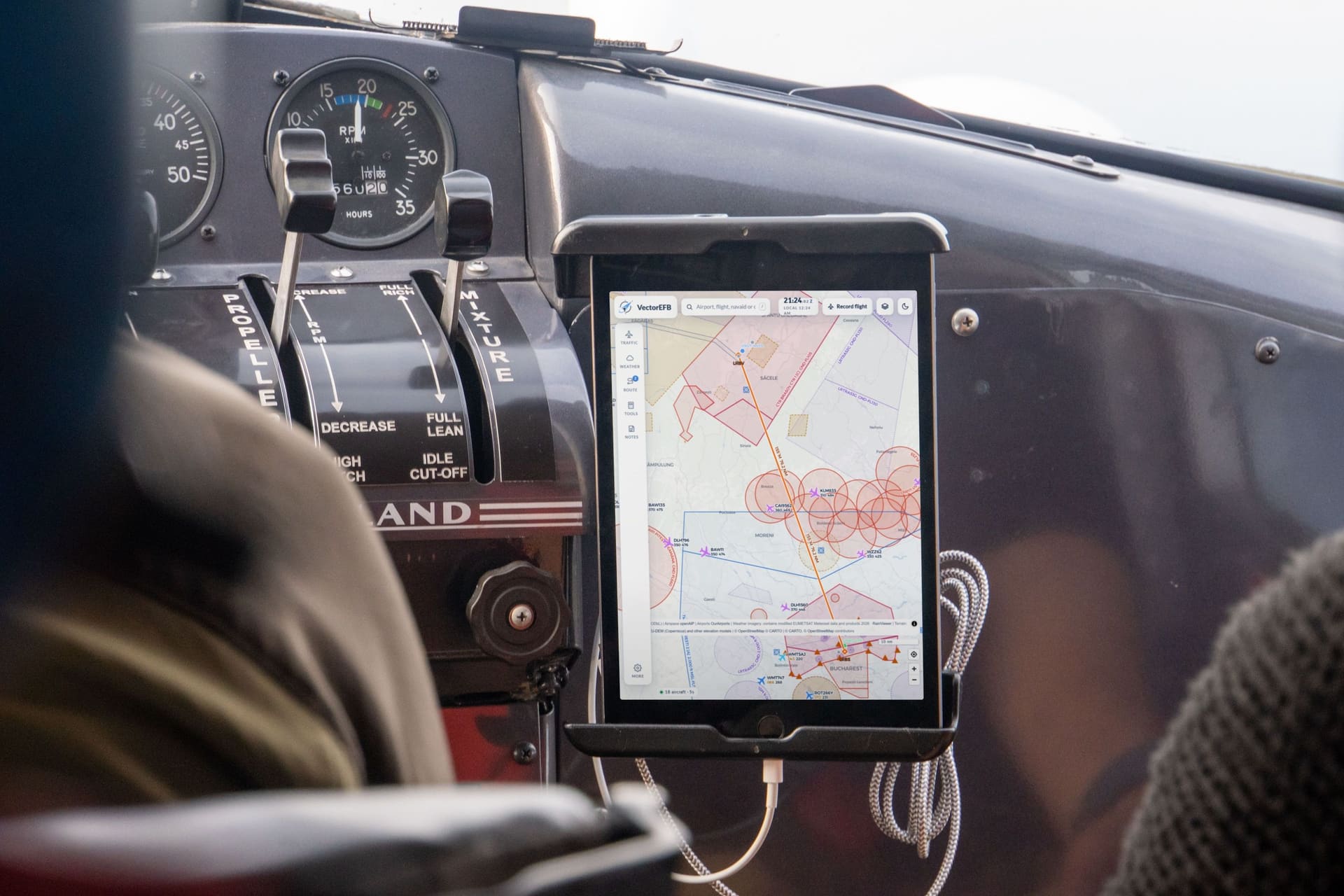 Un iPad montat pe bordul unui avion ușor, cu harta VectorEFB și o rută de la Brașov la București. Ecranul este o ilustrație adăugată peste o fotografie de stoc.