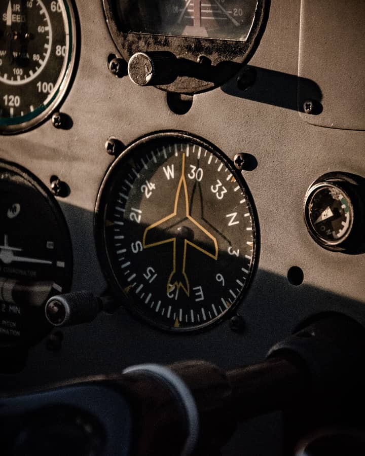Prim-plan cu un indicator de cap pe bordul unui avion, în lumina joasă de seară, cu simbolul avionului între capurile 30 și 33.